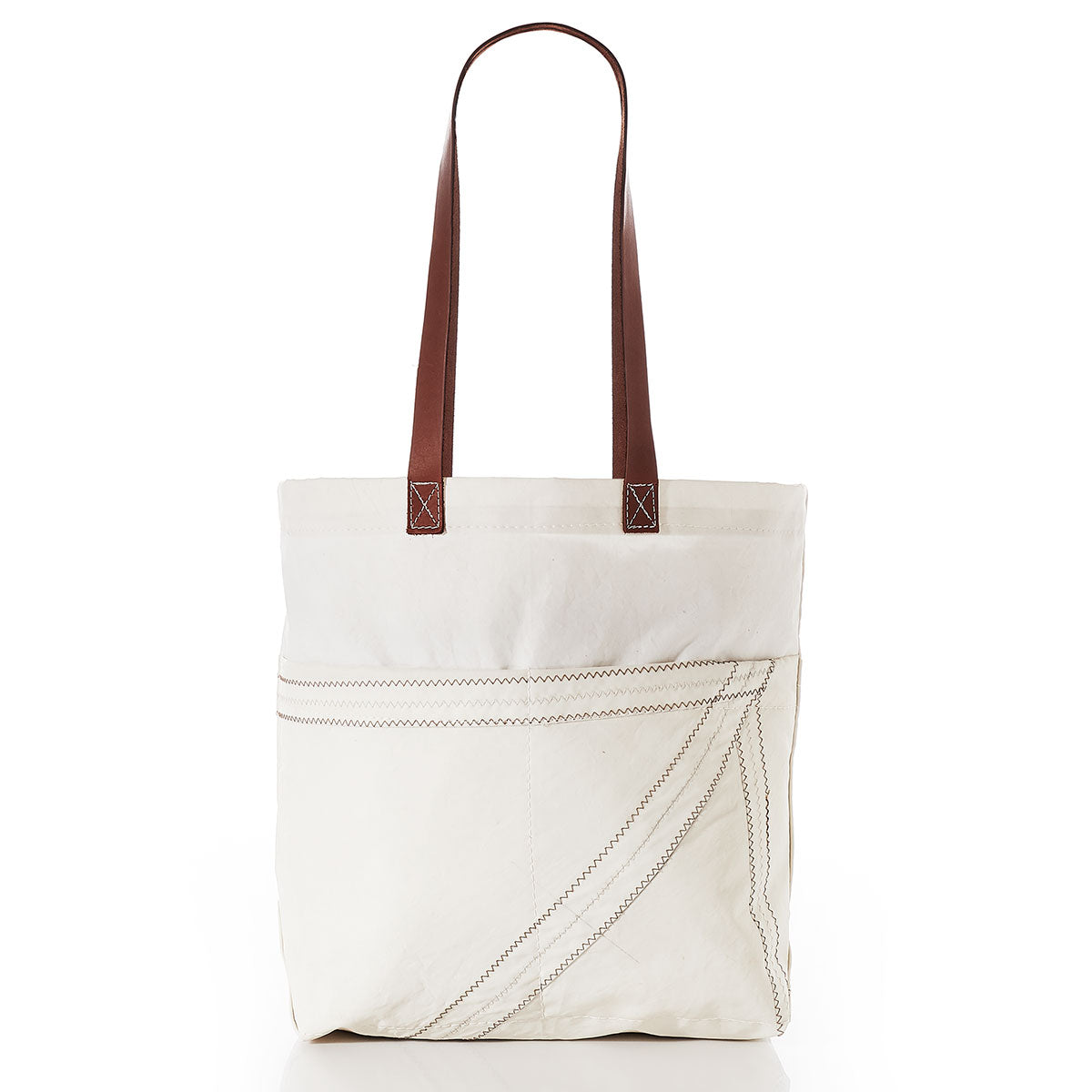 Sea Bags Market Tote in white canvas features brown leather shoulder straps, a leather handle, and prominent diagonal stitching on the front pocket, displayed against a white background. by Sea Bags