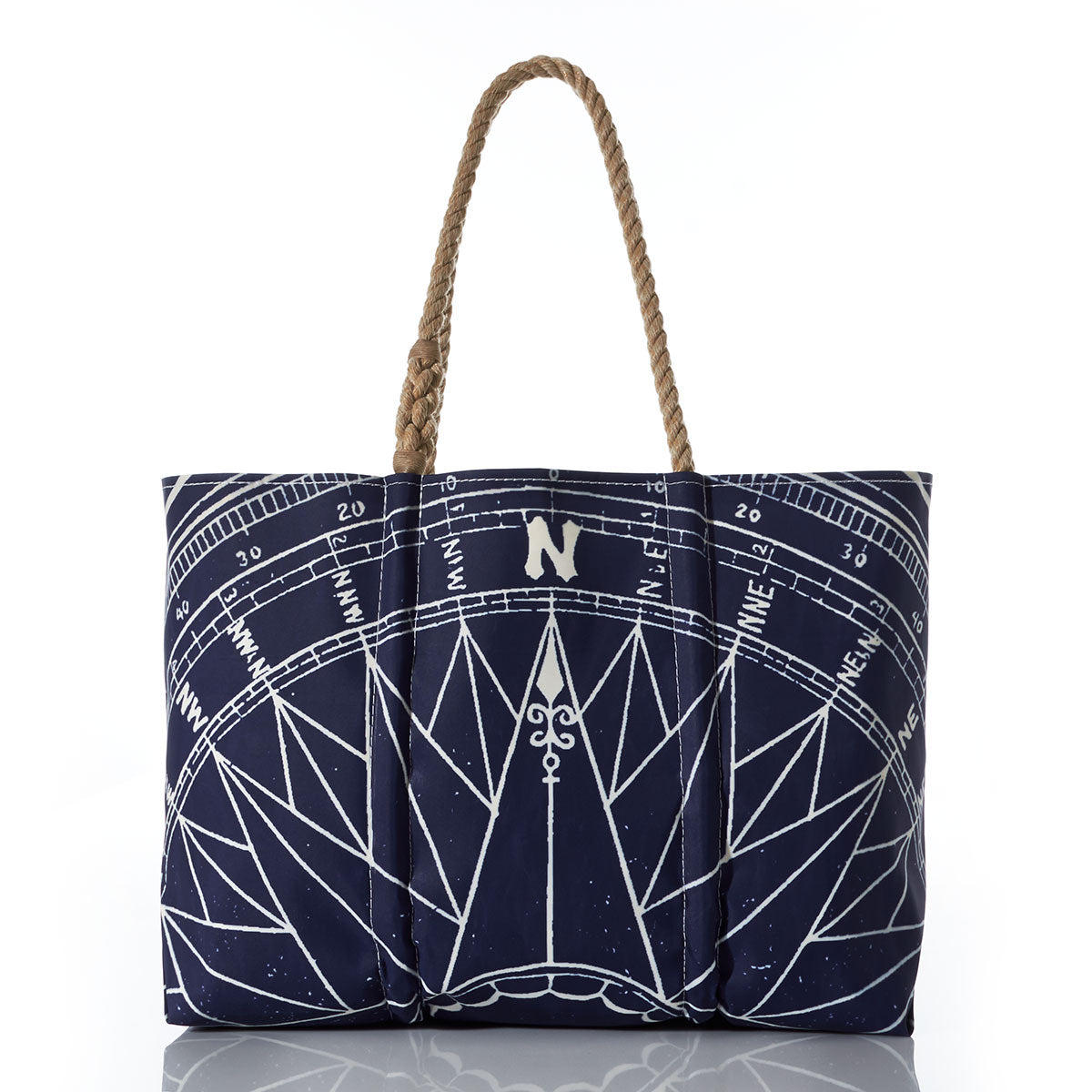 Introducing the Navy True North Large Tote by Sea Bags—a spacious navy blue tote crafted from recycled sailcloth, featuring a striking white nautical compass rose design and brown braided handles. Displayed against a white background, its the perfect nautical gift. by Sea Bags