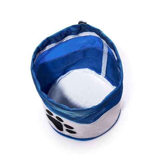 The Sea Bags Paw Print Ditty Bag, featuring a black paw print on blue and white fabric, is seen from above on a white background—ideal for pairing with your eco-friendly pet bowl or matching recycled sail bags for travel and outings. by Sea Bags