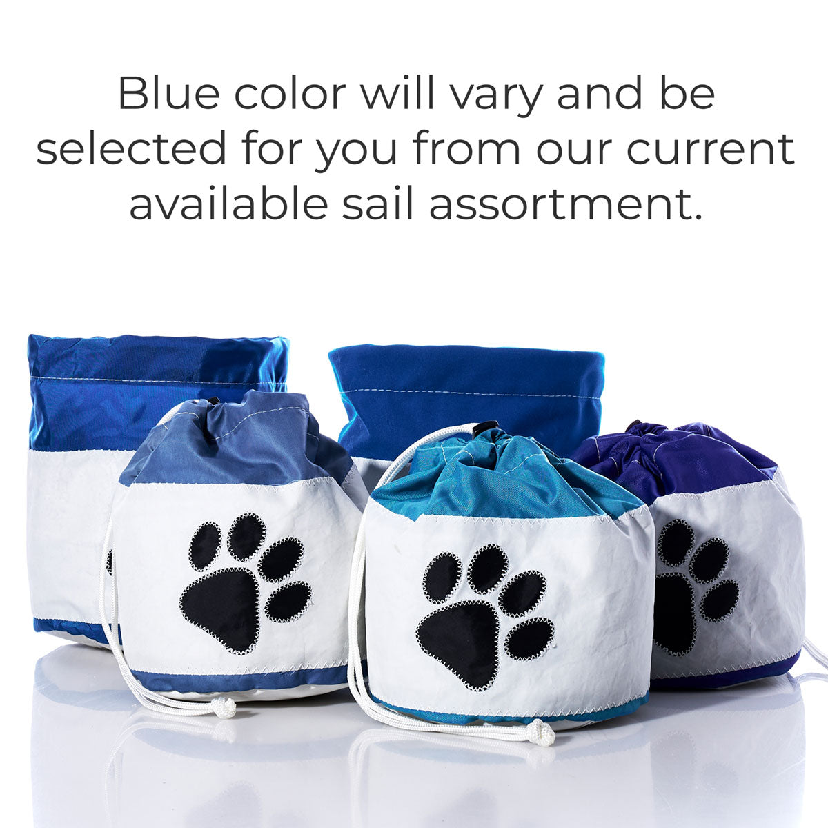 Five Sea Bags Paw Print Ditty Bags are displayed in a mix of blue and white fabrics, each with a black paw print design and convenient drawstring closure. These eco-friendly accessories are ideal for storing pet treats or toys. Please note: the shade of blue may vary depending on current stock. by Sea Bags
