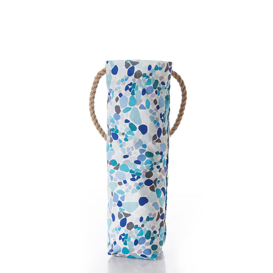 The Sea Bags Sea Glass Print Wine Bag, crafted from recycled sail cloth, features a blue, teal, and gray pebble pattern inspired by sea glass and is finished with two rope handles. The bag stands upright against a white background. by Sea Bags