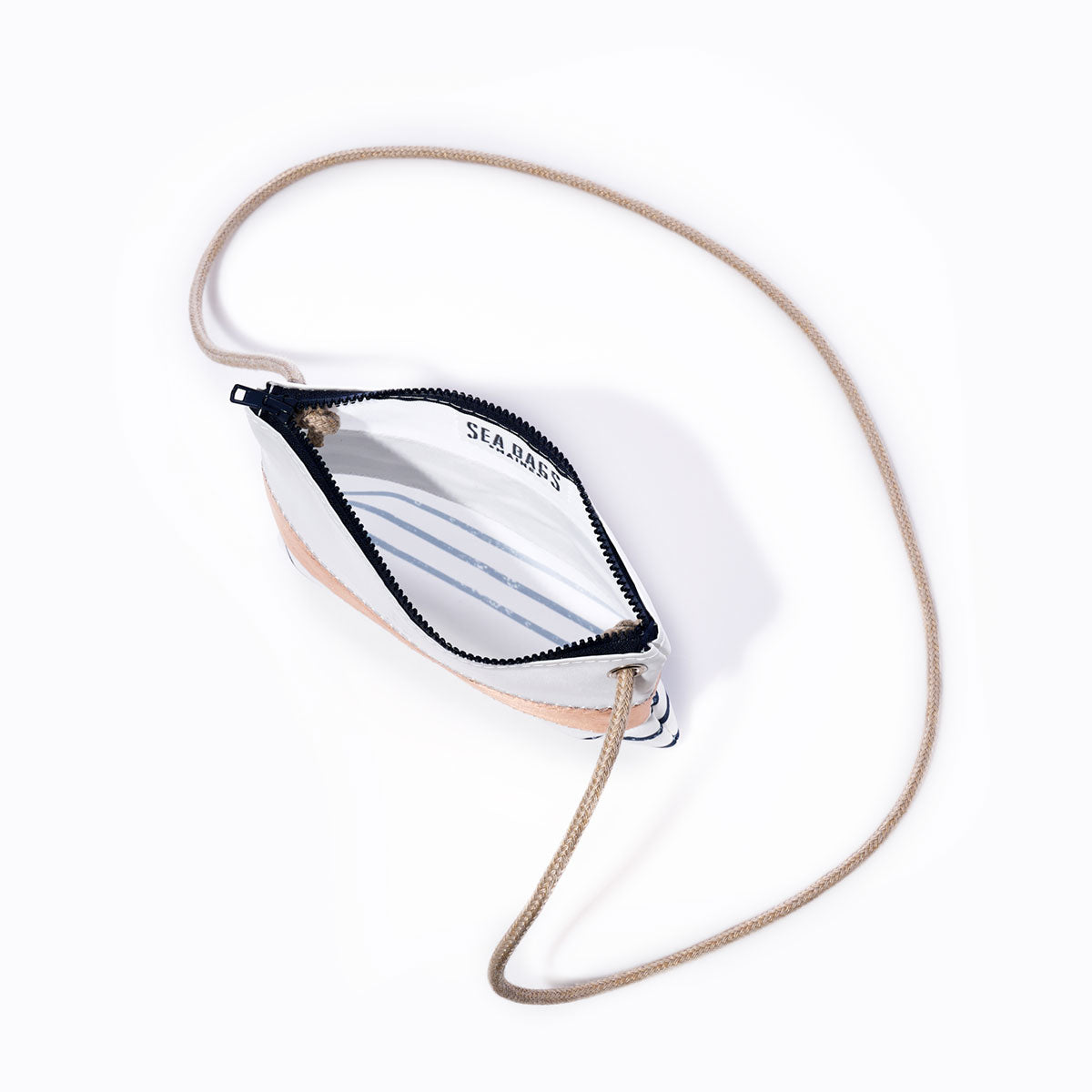 A Rose Gold-on-Navy Mariner Stripe Slim Crossbody Bag by Sea Bags, featuring a small handcrafted design with a tan rope strap and zippered closure, is shown open to reveal a white interior with blue Breton stripes and the SEA BAGS logo printed inside, photographed on a plain white background. by Sea Bags