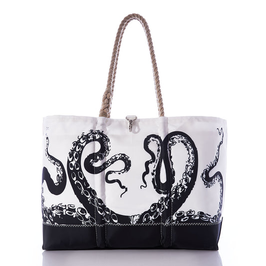 The Sea Bags Octopus Ogunquit Beach Tote features a white and black design with a rope handle, showcasing a vintage octopus tentacle illustration on the front. Crafted from recycled sail cloth, this distinctive beach bag blends style and sustainability for your coastal adventures. by Sea Bags