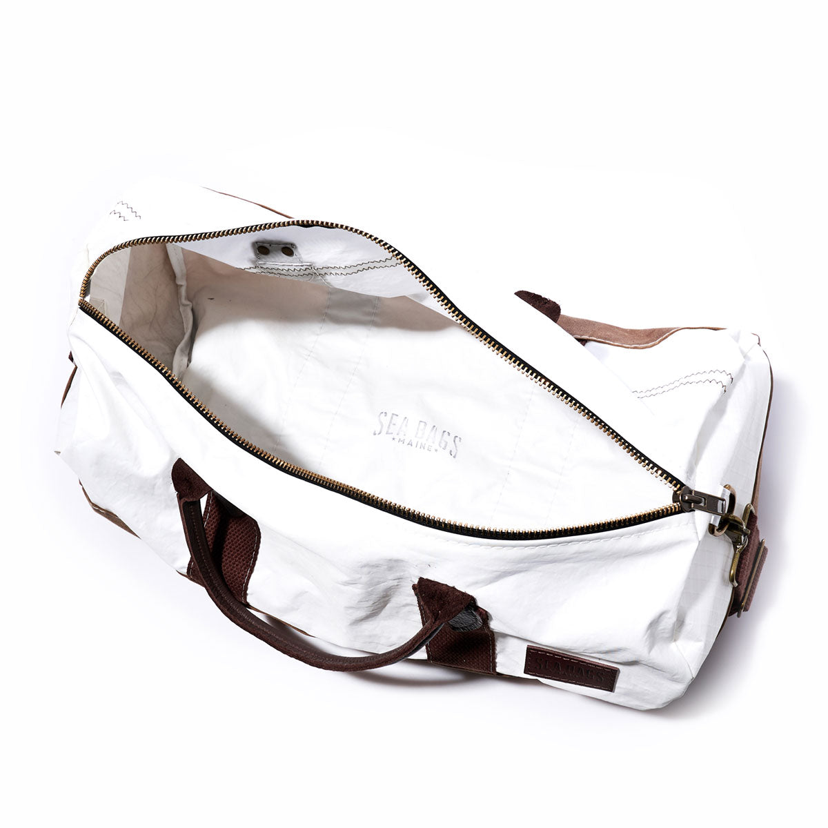 The Sea Bags Tan Chebeague Duffel features a white waxed canvas exterior, brown handles, and an open zipper that reveals a spacious, unlined interior. by Sea Bags