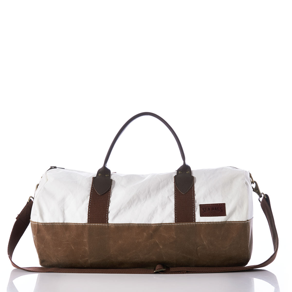 The Sea Bags Tan Chebeague Duffel, shown on a white background, is a maritime travel bag with a white canvas top, brown leather bottom, brown handles, and a detachable shoulder strap. by Sea Bags