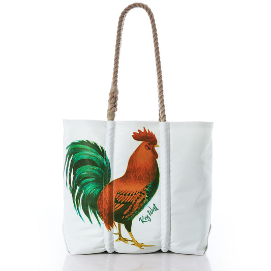 Introducing the Key West Rooster Medium Tote by Sea Bags—a white tote crafted in the USA from recycled sail cloth, accented with brown rope handles. This eco-friendly bag features a vibrant rooster illustration and Key West text on the front, blending coastal charm with sustainable style. by Sea Bags