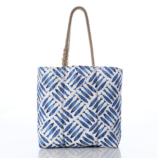 The Sea Bags Fish Print Medium Tote with Clasp features a blue fish pattern and two twisted rope handles, crafted from weather-resistant recycled sails. Shown against a plain white background, this eco-friendly tote is perfect for nautical adventures at the beach. by Sea Bags