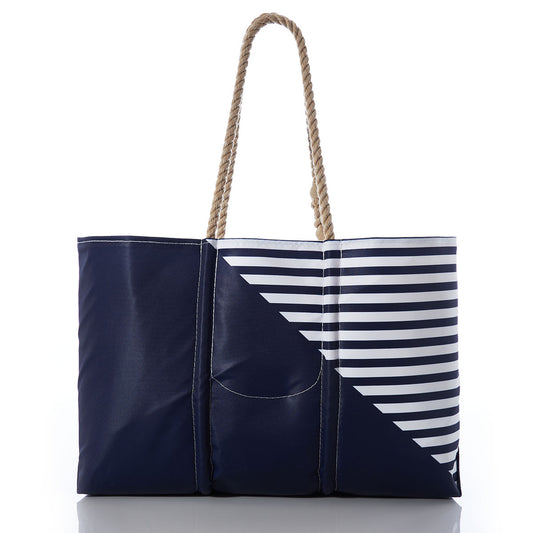 Sea Bags Custom Monogram Breton Stripe Anchor Large Tote features nautical rope handles and is crafted from recycled sail cloth, with a stylish design that combines diagonal white and navy Breton stripes with a solid navy panel, all showcased against a white background. by Sea Bags
