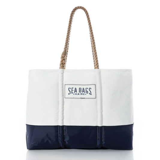Sailmaker’s Tote with Clasp and Hanging Pocket by Sea Bags, crafted from recycled sail cloth in white and navy with rope handles and a Sea Bags label on the front, shown against a white background. by Sea Bags