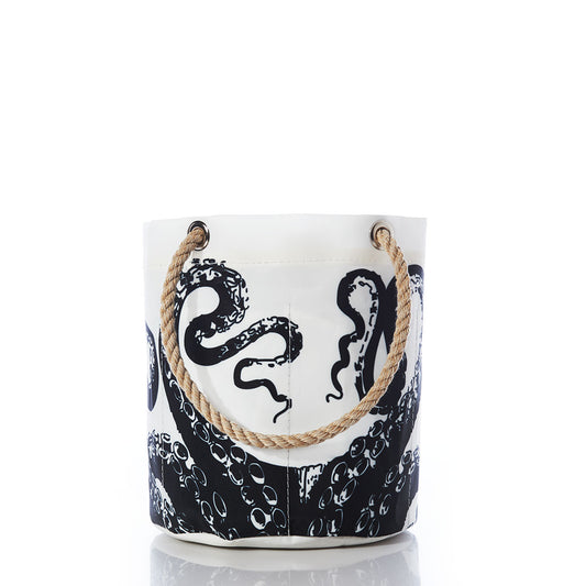 The Sea Bags Octopus Beverage Bucket—a white canvas bucket bag made from recycled sail cloth—features a bold black octopus tentacle print and durable rope handles, blending sustainable style with vintage illustration charm, shown against a white background. by Sea Bags