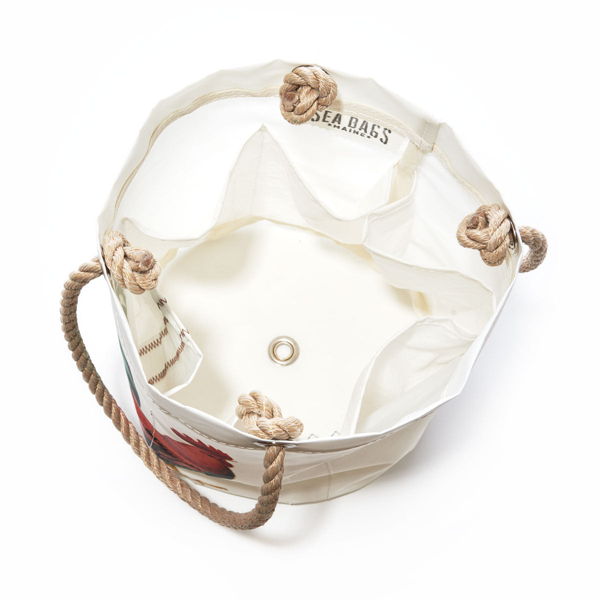 Key West Rooster Beverage Bucket by Sea Bags. Crafted from recycled sail cloth, this white bucket bag features rope handles, a metal grommet on the bottom, and SEA BAGS branding on the interior. The top edge is finished with rope loops, and the interior is open for convenient use. by Sea Bags
