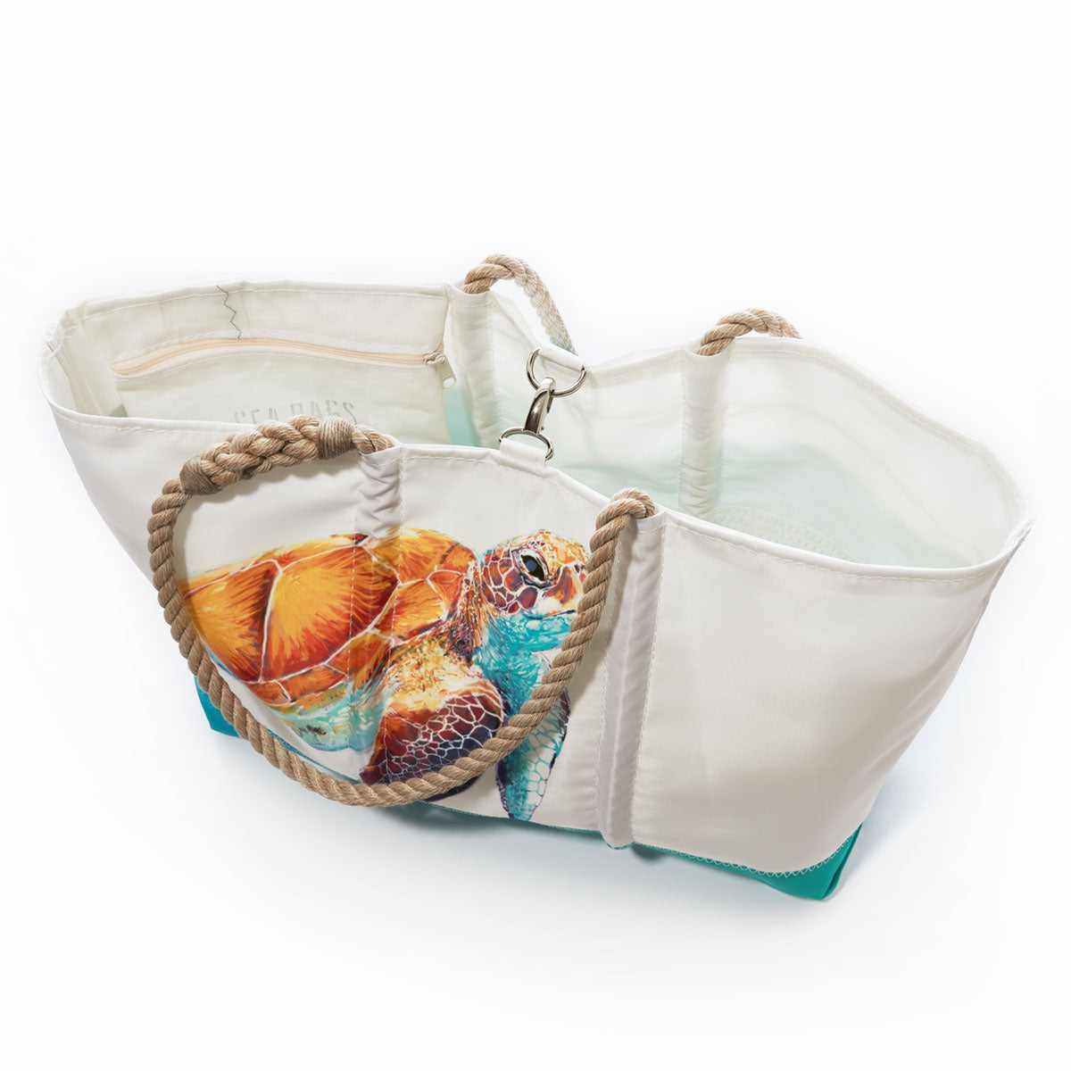 Sea Bags Multicolor Sea Turtle Ogunquit Beach Tote features sturdy rope handles and a vibrant sea turtle illustration on the front; crafted from recycled sails, this tote is lined and includes a zippered interior pocket. by Sea Bags