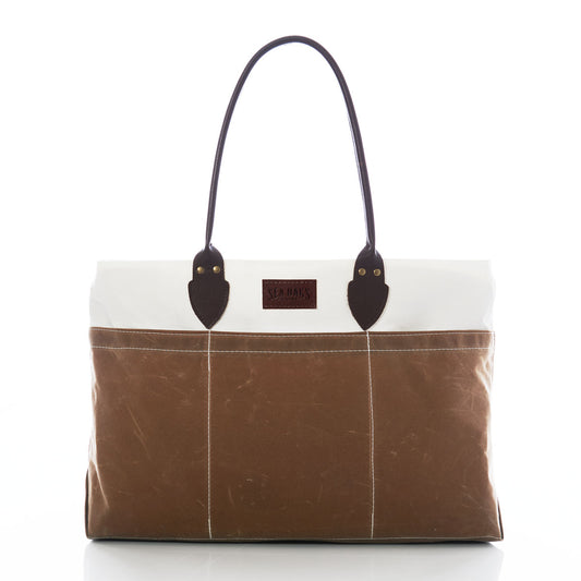 Tan Chebeague Large Travel Tote by Sea Bags, made from recycled sail cloth in brown and white tones, features dark handles, stitched vertical lines, and a rectangular front label, photographed on a white background. by Sea Bags