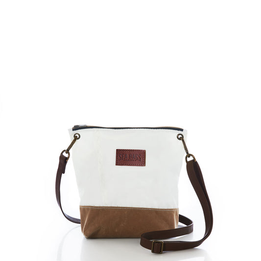 Tan Chebeague Crossbody Bag by Sea Bags featuring a white and brown design with a leather Sea Bags patch, zippered top, and dark adjustable strap, shown against a white background. This hands-free crossbody bag delivers effortless everyday carry in authentic nautical style. by Sea Bags