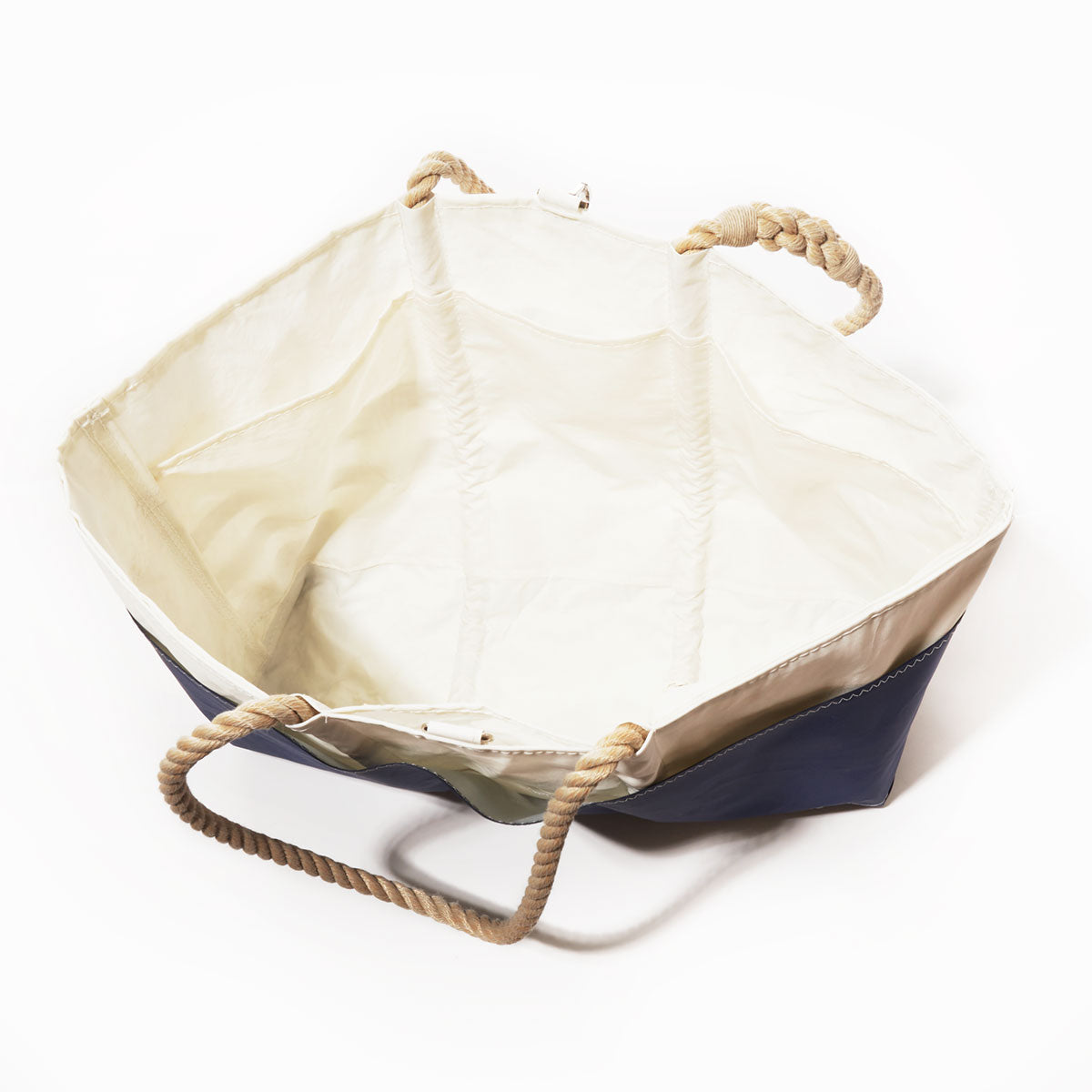 The Sea Bags Breton Stripe Whale Ogunquit Beach Tote is a large, open nautical bag made from recycled sail cloth, showcasing a navy blue exterior with classic Breton stripes, a crisp white interior, and sturdy twisted rope handles. Shown on a white background, this eco-friendly tote is perfect for seaside adventures. by Sea Bags