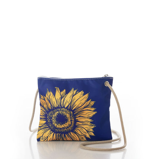 The Sea Bags Sunflower Slim Crossbody features a small blue design adorned with a yellow sunflower graphic, complemented by a beige rope strap and secure zipper closure. Ideal for nature lovers or anyone looking for a minimalist accessory, this bag is shown on a white background with its reflection visible underneath. by Sea Bags