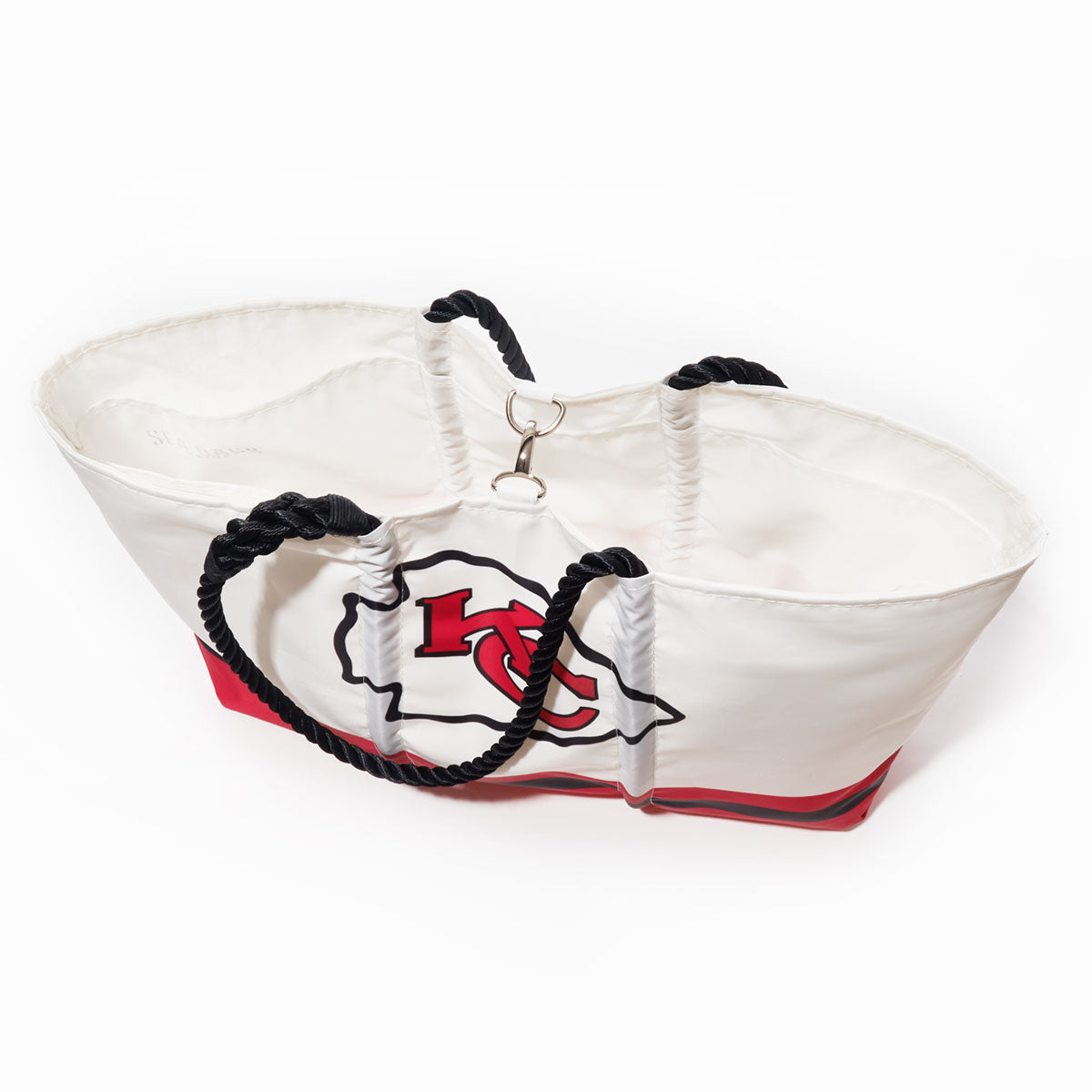 The Kansas City Chiefs Tailgate Tote by Sea Bags is crafted from recycled sail cloth in bold white and red, accented with black rope handles and a metal clasp. Showcasing the iconic Kansas City Chiefs logo, this durable bag is photographed against a clean white background—an ideal blend of style and function for any devoted fan. by Sea Bags