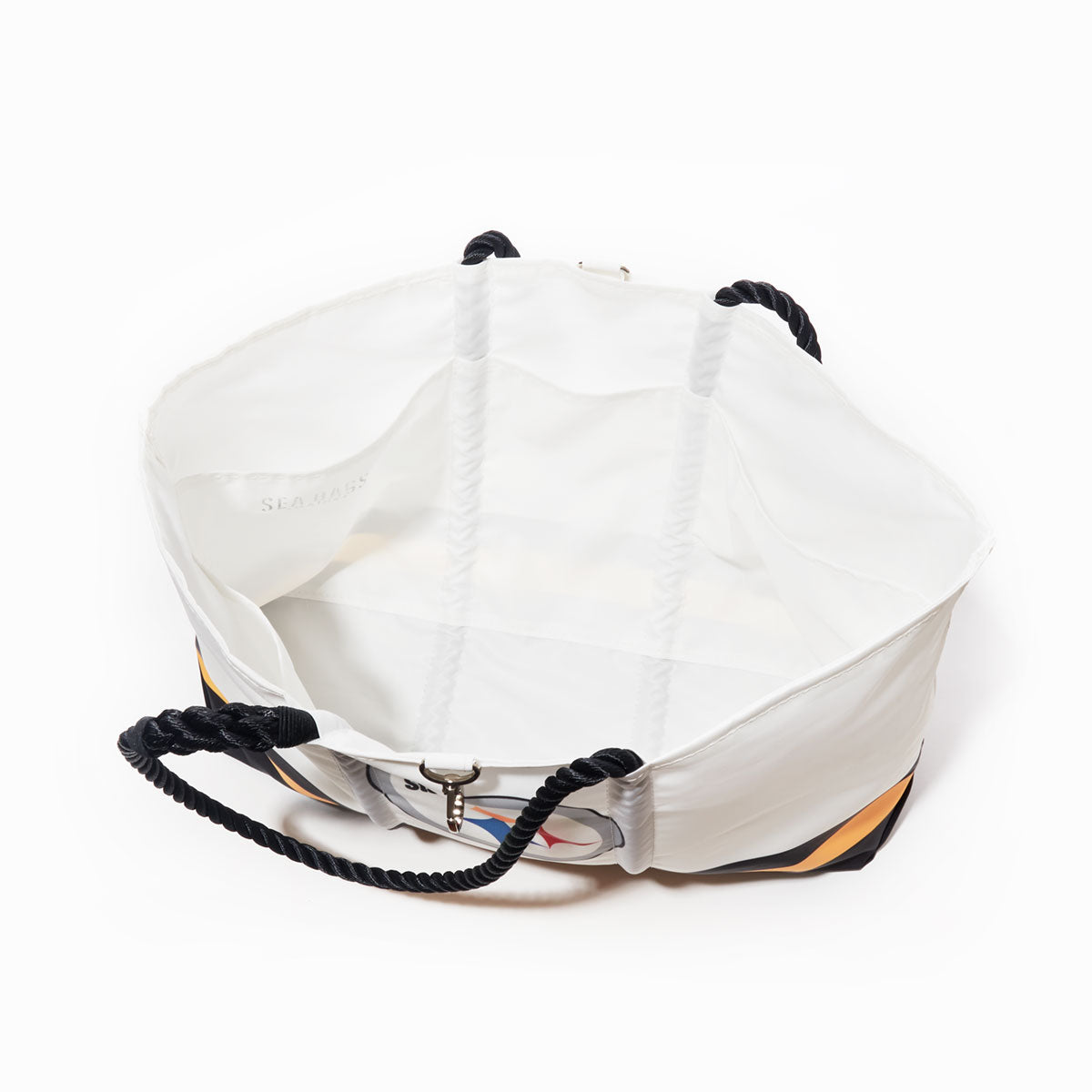 The Pittsburgh Steelers Tailgate Tote by Sea Bags is an open-top white tote made from recycled sail cloth, featuring black rope handles and visible stitching. Shot from above against a white background, its empty interior and metal clasp are showcased—making it the perfect stylish game-day accessory for Steelers fans. by Sea Bags