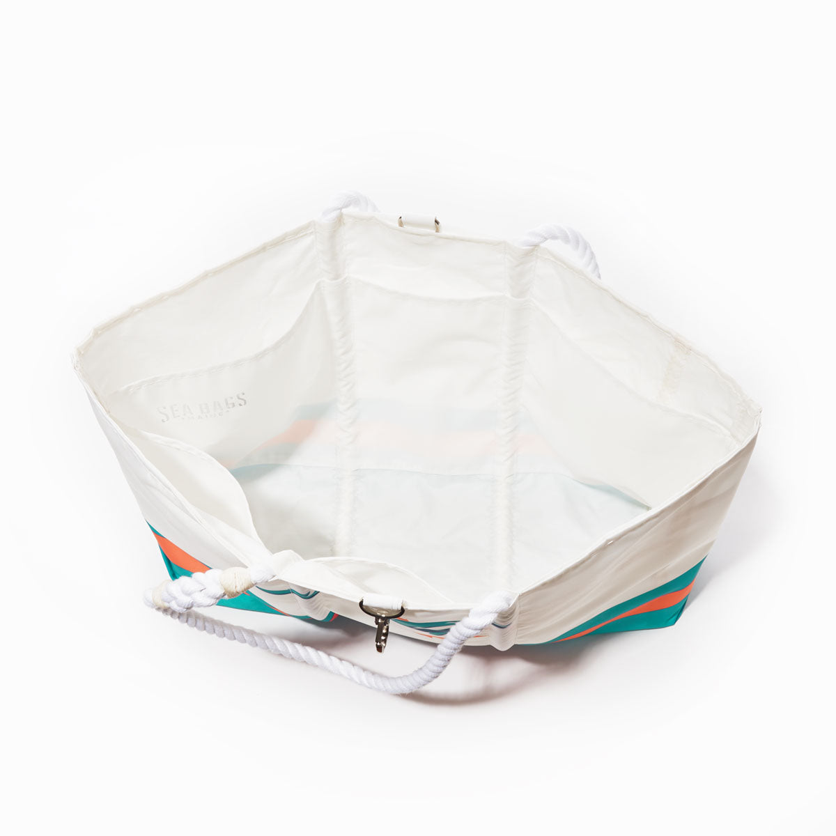 The Sea Bags Miami Dolphins Tailgate Tote features a white hexagonal design with teal and coral stripes, open at the top to reveal sturdy white rope handles and a spacious interior. Crafted from recycled sail cloth, this bag captures a fresh nautical vibe—making it the perfect accessory for Miami Dolphins game days or tailgate parties. by Sea Bags