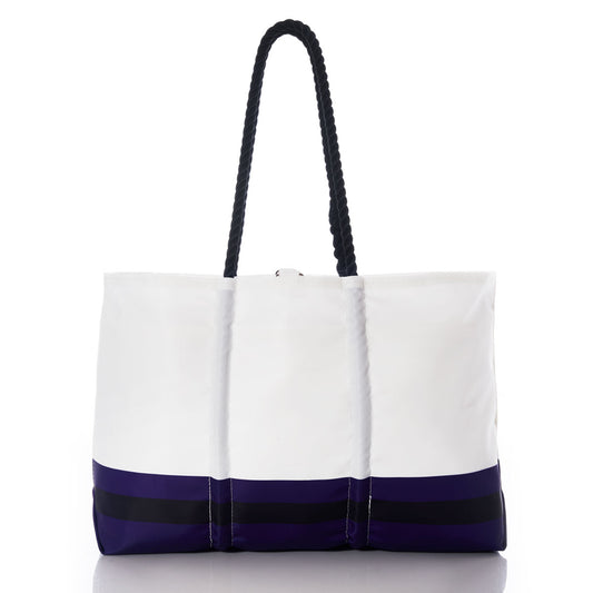 The Sea Bags Baltimore Ravens Tailgate Tote, crafted from recycled sail cloth, features a white body with black handles and a navy blue bottom edge accented by two horizontal black stripes. Displayed on a white background, this bold tote echoes the spirit of the classic Baltimore Ravens logo bag. by Sea Bags