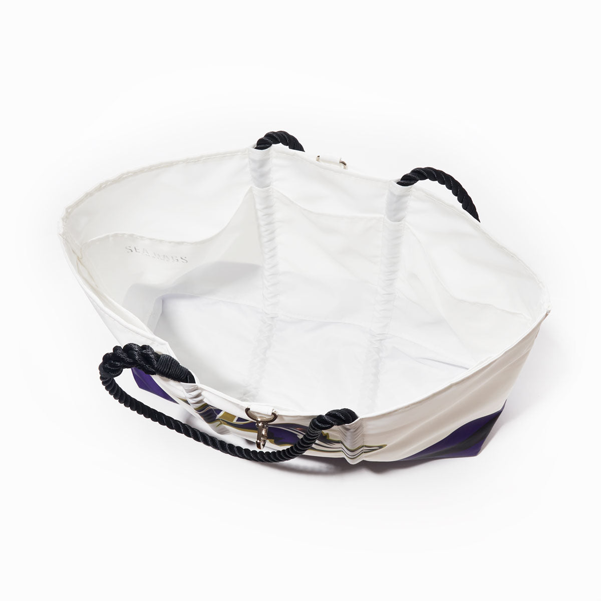 The Baltimore Ravens Tailgate Tote by Sea Bags is an open, empty white tote bag made from recycled sail cloth, featuring black twisted rope handles and a white interior. Shown from above against a plain background, it’s the perfect choice for your next tailgate. by Sea Bags