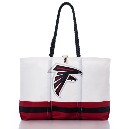 Flaunt your team pride with the Atlanta Falcons Tailgate Tote by Sea Bags, expertly crafted from recycled sail cloth. This chic white tote showcases durable black handles, the iconic Atlanta Falcons NFL logo, and striking red and black stripes along the bottom—all beautifully captured on a clean white backdrop. by Sea Bags