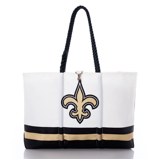 Carry your team spirit in style with the Sea Bags New Orleans Saints Tailgate Tote—crafted from durable recycled sail cloth, this white tote features black rope handles, eye-catching gold and black horizontal stripes near the base, and a bold fleur-de-lis symbol on the front, making it the perfect accessory for any Saints fan. by Sea Bags