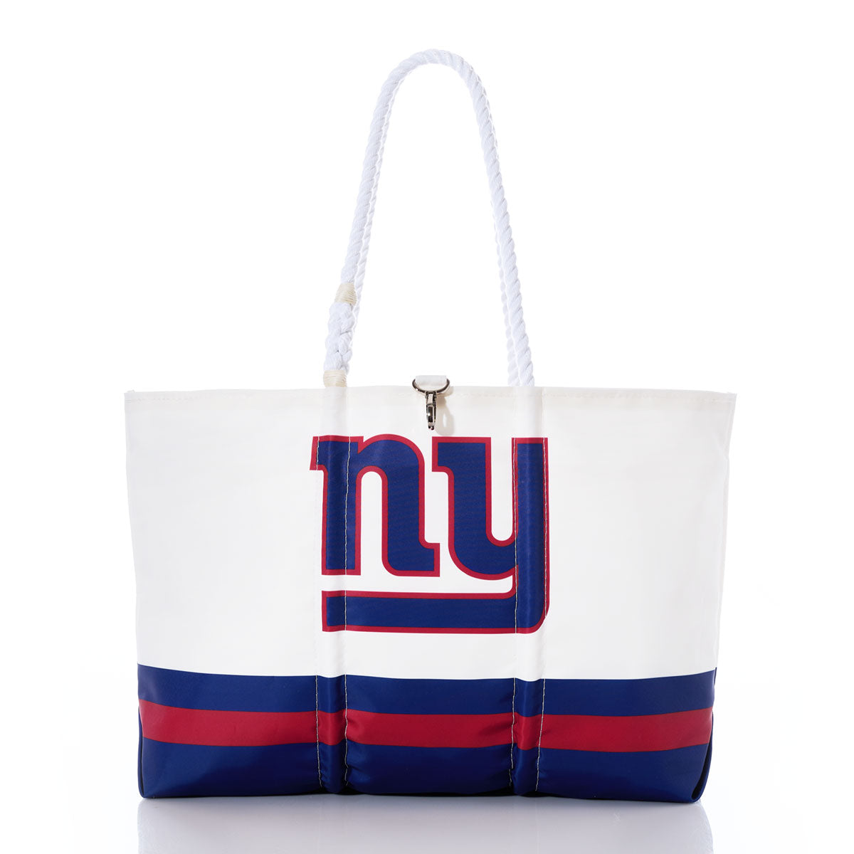 The Sea Bags New York Giants Tailgate Tote is made from recycled sail cloth for enhanced durability and features a bold NY logo on the front, accented with blue and red stripes. With sturdy rope handles and a clasp closure, this versatile tote—shown against a white background—is the perfect accessory for game day or casual outings. by Sea Bags