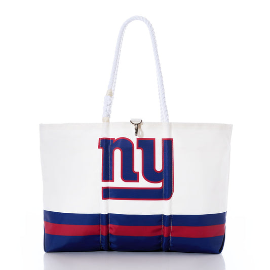 The Sea Bags New York Giants Tailgate Tote is made from recycled sail cloth for enhanced durability and features a bold NY logo on the front, accented with blue and red stripes. With sturdy rope handles and a clasp closure, this versatile tote—shown against a white background—is the perfect accessory for game day or casual outings. by Sea Bags