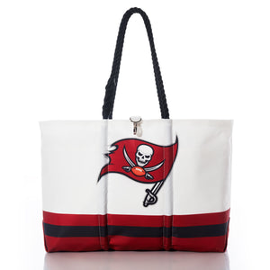 The Sea Bags Tampa Bay Buccaneers Tailgate Tote is crafted from recycled sail cloth for durability and eco-friendliness. This white tote bag features black rope handles, the official Tampa Bay Buccaneers logo, and bold red and black stripes along the bottom. Perfect for showing your team spirit, it’s photographed on a white background. by Sea Bags