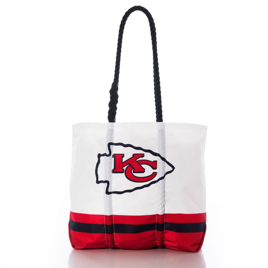 Introducing the Kansas City Chiefs Medium Tote by Sea Bags—a white recycled sail cloth tote with black handles, featuring sturdy red and black bottom stripes and a bold Kansas City Chiefs logo on the front. This eco-friendly, durable bag is perfect for fans. by Sea Bags