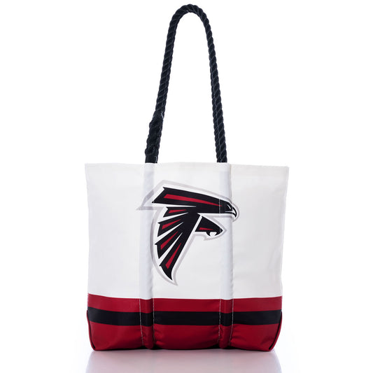 Introducing the Atlanta Falcons Medium Tote by Sea Bags—a white tote featuring black rope handles and striking red and black stripes along the bottom. The front showcases a bold black and red falcon head logo, making it the perfect accessory for any fan. Expertly crafted from recycled sail cloth, this eco-friendly tote combines style with team pride for every outing. by Sea Bags