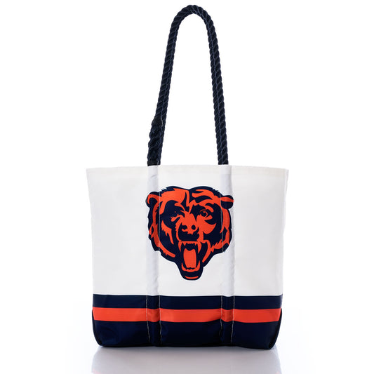 The Chicago Bears Medium Tote by Sea Bags is crafted from recycled sail cloth and features a white design with navy and orange stripes at the bottom, a bear head logo in the center, and two thick, rope-style black handles—combining eco-friendly materials with team spirit. by Sea Bags