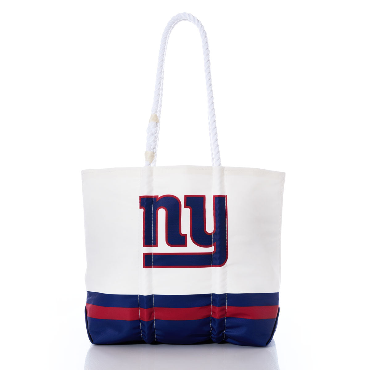Introducing the New York Giants Medium Tote by Sea Bags—a stylish accessory crafted from recycled sail cloth. This white tote features bold blue and red stripes at the base, a prominent NY logo on the front, and two sturdy white rope handles, creating a unique NFL-inspired bag that perfectly blends team spirit with sustainability. by Sea Bags