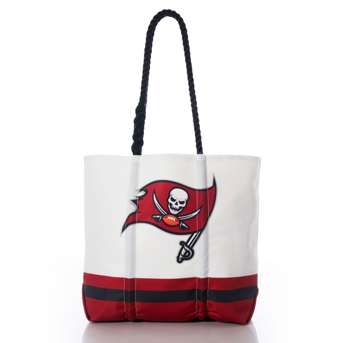 Introducing the Tampa Bay Buccaneers Medium Tote from Sea Bags—a white tote bag made from recycled sail cloth, featuring sturdy black rope handles, striking red and black bottom stripes, and a bold red pirate flag with a skull and crossed swords logo on the front. This sustainable team bag is an ideal choice for Tampa Bay NFL fans who want to combine style and eco-friendly function. by Sea Bags