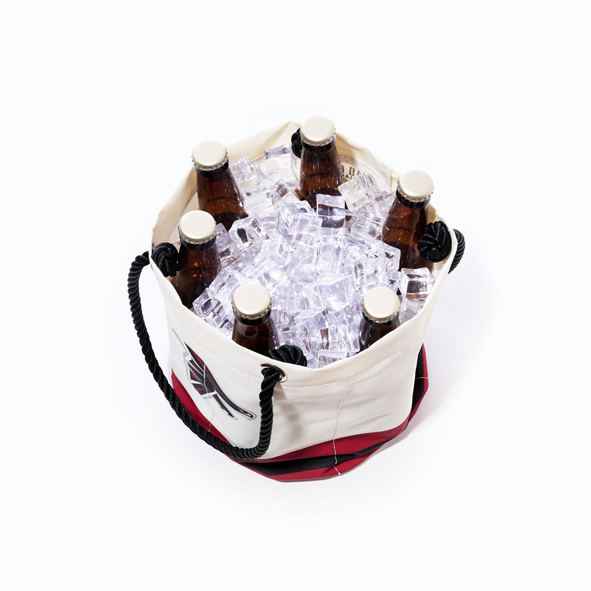 A white and red Atlanta Falcons Beverage Bucket by Sea Bags, reminiscent of an NFL logo cooler, is filled with ice cubes and six capped brown glass bottles, viewed from above. by Sea Bags