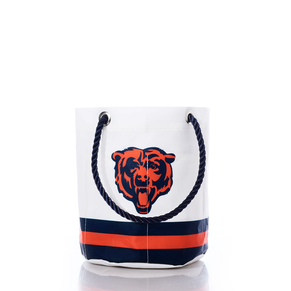 The Sea Bags Chicago Bears Beverage Bucket is a white recycled sail cloth bucket bag with blue rope handles, adorned with a roaring bear logo and horizontal navy and orange stripes near the base—making it the perfect sustainable cooler for showcasing your Chicago Bears pride. by Sea Bags