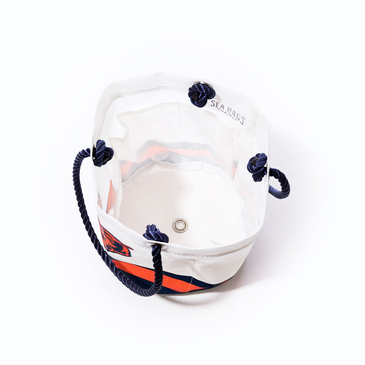 The Chicago Bears Beverage Bucket by Sea Bags is a white and orange canvas bucket bag featuring navy rope handles, an open top, a metal grommet at the bottom, and an interior SEA BAGS label. Crafted from recycled sail cloth beverage bucket material, this sustainable NFL logo bag makes for a unique Chicago Bears cooler—displayed here against a white background. by Sea Bags