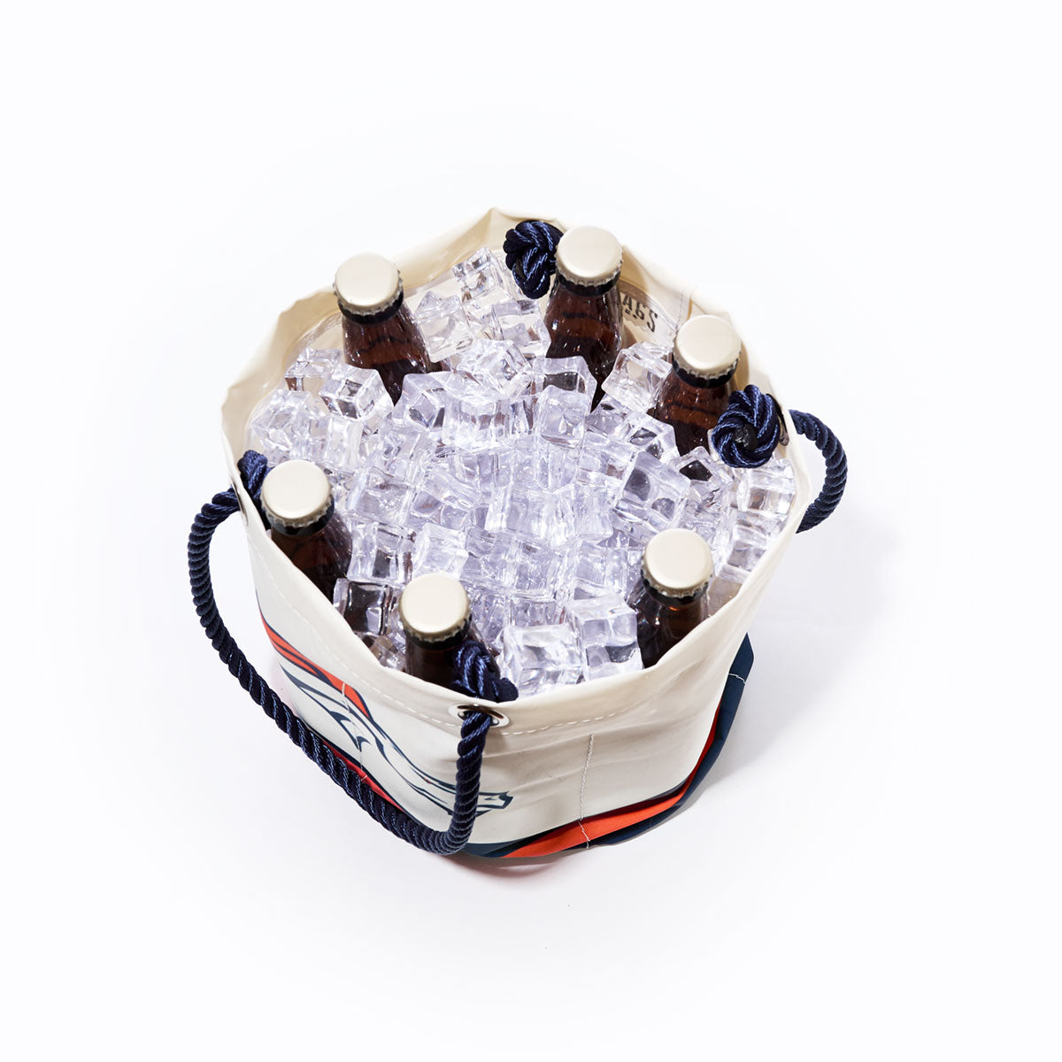Sea Bags Denver Broncos Beverage Bucket, crafted from recycled sail cloth for a sustainable and practical cooler, is shown from above filled with ice cubes and six capped brown glass bottles; blue rope handles on each side add style and function. by Sea Bags