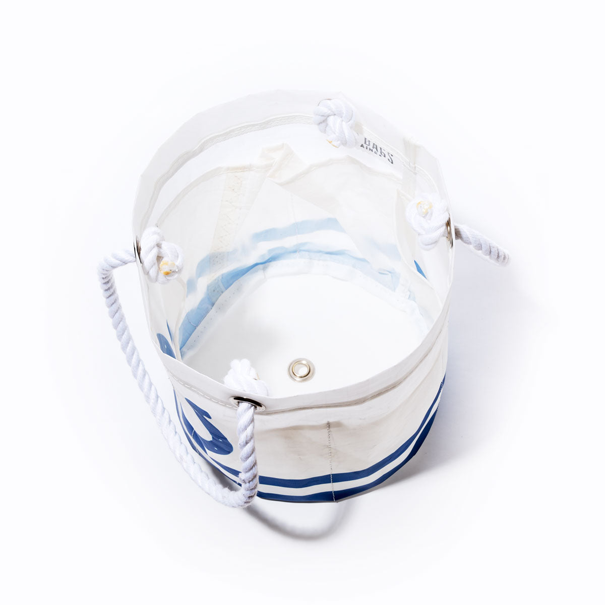 The Sea Bags Indianapolis Colts Beverage Bucket features a white and transparent design with blue stripes, sturdy rope handles threaded through metal grommets, and a circular metal eyelet at the base—capturing the essence of an NFL logo bag—shown from above against a white background. by Sea Bags