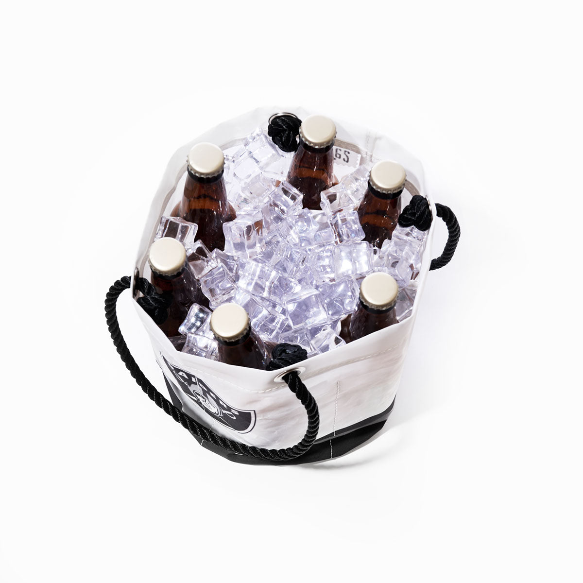 Six brown glass bottles in a Sea Bags Las Vegas Raiders Beverage Bucket filled with ice cubes, viewed from above, against a white background. by Sea Bags