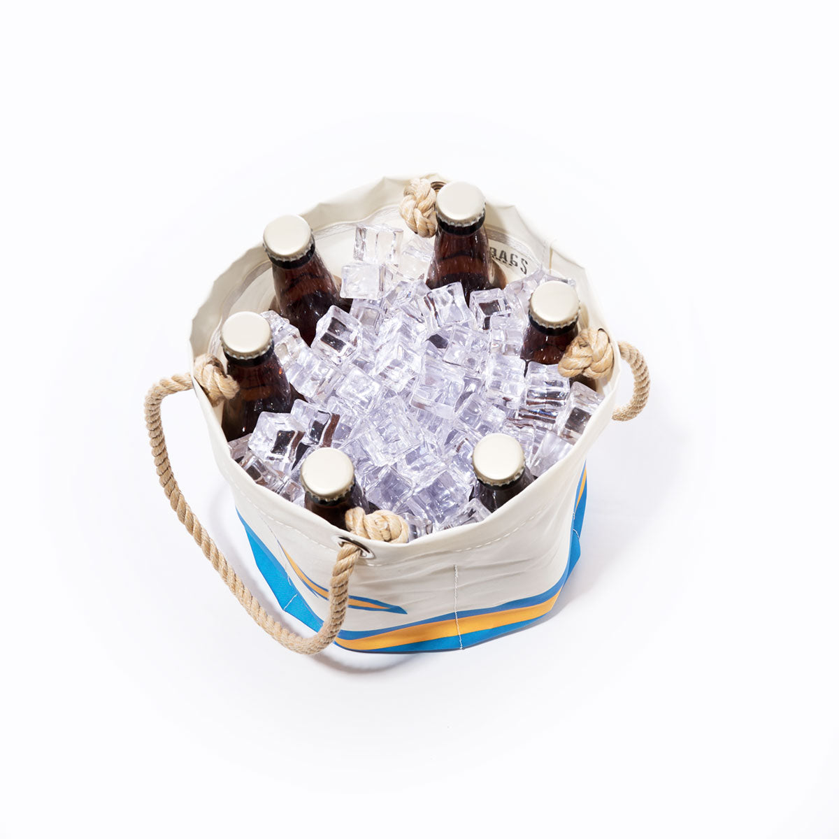 Six brown glass bottles rest in the Los Angeles Chargers Beverage Bucket by Sea Bags, crafted from recycled sail cloth and filled with ice cubes. Seen from above on a white background, this sustainable cooler is perfect for any occasion. by Sea Bags