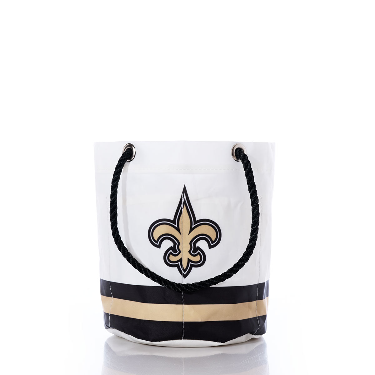 Introducing the New Orleans Saints Beverage Bucket by Sea Bags—a white tote with sturdy black rope handles, adorned with a striking gold and black fleur-de-lis logo and accented by bold horizontal stripes in black and gold at the base. This stylish and sustainable bucket is perfect for any New Orleans Saints fan’s collection or as a chic alternative to a cooler for carrying your favorite beverages and essentials. by Sea Bags