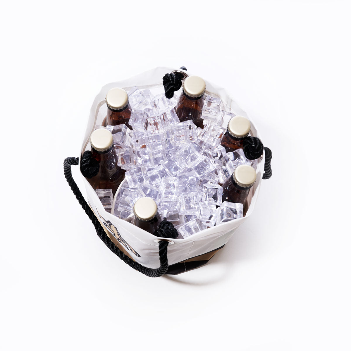 Six brown glass bottles with gold caps are placed upright in a Sea Bags New Orleans Saints Beverage Bucket filled with clear ice cubes, viewed from above on a white background. by Sea Bags