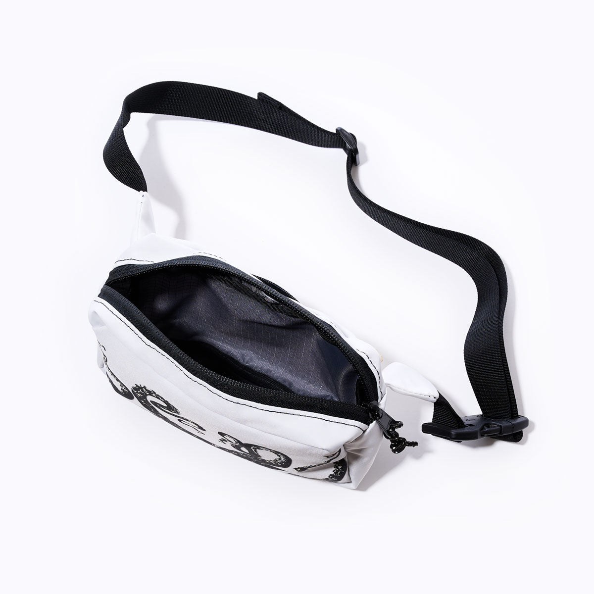 The Sea Bags Octopus Belt Bag is a compact white waist bag made from recycled sail cloth, featuring a zippered closure and a black adjustable strap. Shown open to reveal its empty interior against a plain white background, its the ideal belt bag for carrying your travel essentials. by Sea Bags