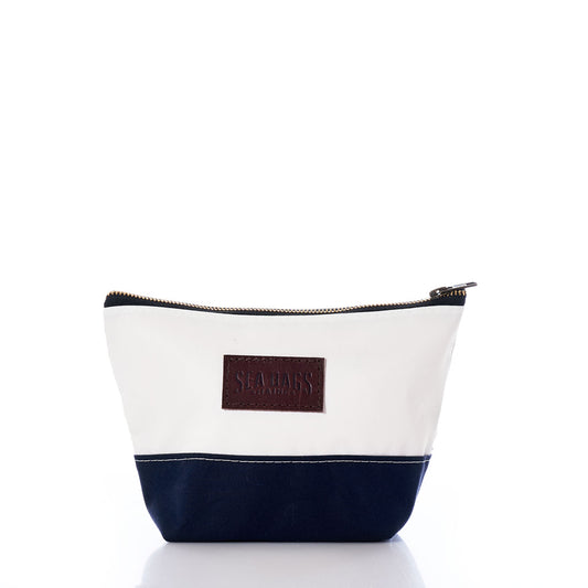 Introducing the Chebeague Cosmetic Bag by Sea Bags—a zippered pouch crafted from recycled sailcloth, featuring a crisp white top, navy blue bottom, and a brown rectangular patch with the Sea Bags logo. Eco-friendly and stylish, its the perfect blend of canvas and leather for your essentials. by Sea Bags