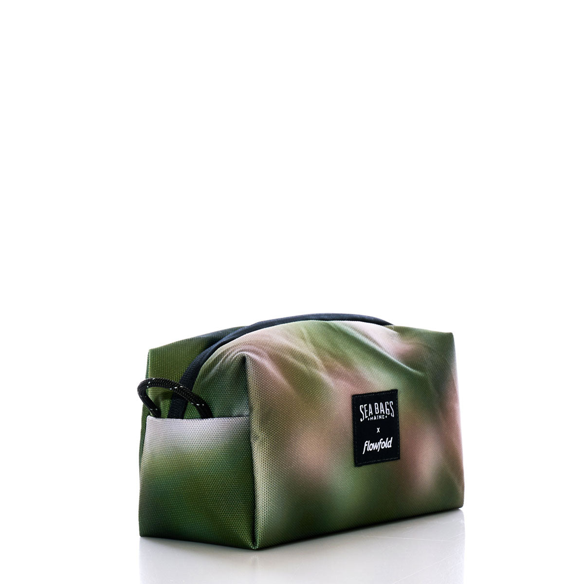 The Dragon Skin Toiletry Bag by Sea Bags features a rectangular shape with a green and brown abstract pattern, black zipper, and a front label reading SEABAGS x flowfold. Displayed on a white background, this sustainable pouch offers practical organization while showcasing eco-friendly style. by Sea Bags
