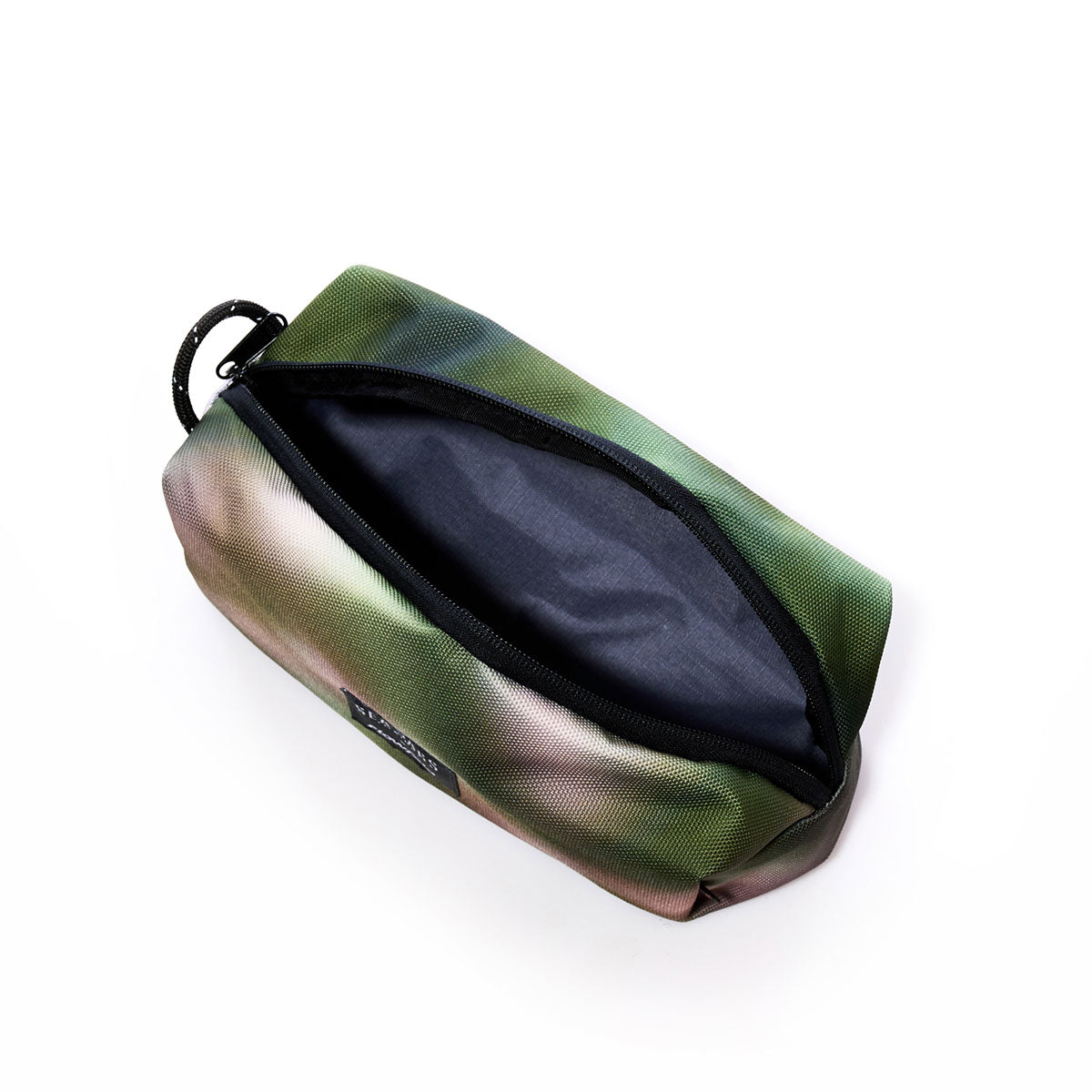 A compact Dragon Skin Toiletry Bag by Sea Bags, featuring a zippered closure, green and brown camouflage design, durable black interior, and a handy black carabiner—an eco-friendly choice for everyday travel essentials. by Sea Bags