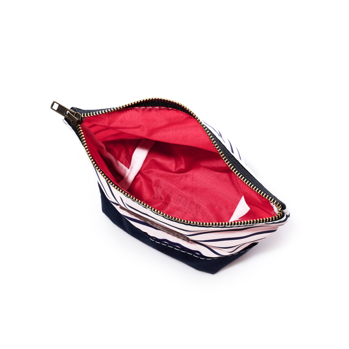 The Sea Bags Navy Mariner Stripe Chebeague Cosmetic Bag is a small zippered pouch crafted from recycled sailcloth, featuring a blue and white striped exterior and a vibrant red interior, displayed open and empty against a white background. by Sea Bags