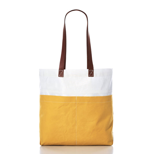 The Sea Bags Golden Yellow Chebeague Market Tote showcases a bold two-tone design, pairing a crisp white upper with a vibrant golden yellow lower section. Sturdy brown leather handles and visible stitching add to its appeal. Expertly handcrafted from recycled sails, this tote is photographed against a white background. by Sea Bags